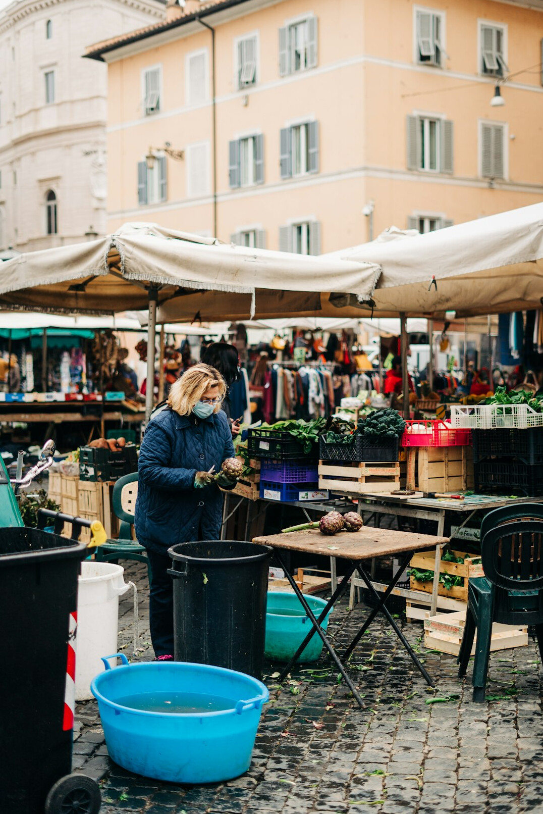 Vendor arranging produce at an outdoor market stall